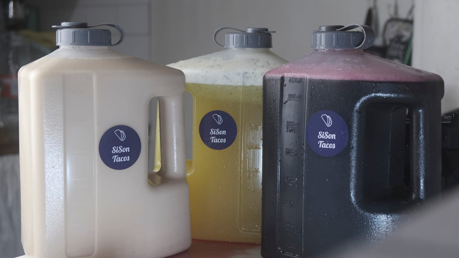 Fresh aguas frescas in Sison Tacos branded jugs
